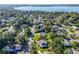 Gorgeous aerial view of a well maintained home with a vibrant green lawn surrounded by mature trees near the water at 1405 Hilltop Dr, Mount Dora, FL 32757