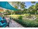 Spacious backyard with patio furniture, lush landscaping, mature trees and manicured garden at 1405 Hilltop Dr, Mount Dora, FL 32757