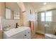 Bathroom features a tiled shower and a vanity with white countertop and ample storage at 1405 Hilltop Dr, Mount Dora, FL 32757