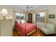 Bedroom with hardwood floors, two windows, ceiling fan and stylish vintage decor at 1405 Hilltop Dr, Mount Dora, FL 32757