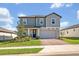 Charming two-story home featuring a brick driveway, two-car garage, and well-manicured lawn at 2298 Raven Ridge Rd, Minneola, FL 34715