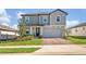 Attractive two story home with a brick driveway, front lawn, and neutral grey trim and siding at 2298 Raven Ridge Rd, Minneola, FL 34715