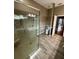 Bathroom features a glass enclosed shower, modern fixtures, and wood-look tile flooring at 3721 Plantation Blvd, Leesburg, FL 34748