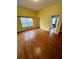 Bright bedroom with wood floors, double closet, and a view into the bathroom at 3721 Plantation Blvd, Leesburg, FL 34748