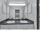 Bathroom vanity with double sinks, dark granite countertop, and modern fixtures at 956 Chula Ct, The Villages, FL 32159