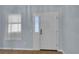 A white entry door with decorative windows leads into a home with light blue walls and wood flooring at 956 Chula Ct, The Villages, FL 32159