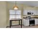 Eat-in kitchen area featuring a table, oven, light fixture and white cabinetry at 956 Chula Ct, The Villages, FL 32159