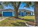 Single story home with blue garage door and landscaping at 1150 Angela Ridge Ct, Kissimmee, FL 34747