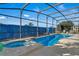 Large, screened pool and spa with a blue fence at 1150 Angela Ridge Ct, Kissimmee, FL 34747