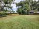 The expansive backyard offers a beautiful lawn with trees and fencing at 351 W 10Th Ave, Mount Dora, FL 32757