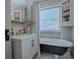 Charming bathroom featuring a clawfoot tub, vintage-style vanity, and ample natural light from a window at 351 W 10Th Ave, Mount Dora, FL 32757