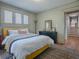 Bedroom with hardwood floors, a yellow upholstered bed, and a black dresser with framed photos at 351 W 10Th Ave, Mount Dora, FL 32757