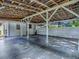 View of the open carport showing beams, support posts, and concrete flooring at 351 W 10Th Ave, Mount Dora, FL 32757