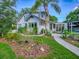 Quaint two-story home with a lush, landscaped front yard with palm trees and white siding at 351 W 10Th Ave, Mount Dora, FL 32757