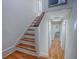 Bright foyer staircase featuring hardwood steps and a white painted banister leading to the upper level of the home at 351 W 10Th Ave, Mount Dora, FL 32757