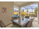 Outdoor patio with a dining table under a covered patio with a view of a fenced pool area at 4847 Clock Tower Dr, Kissimmee, FL 34746