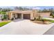 Tan one-story home with brown garage door and landscaped yard at 1440 Fillmore Pl, The Villages, FL 32162