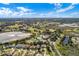 Expansive aerial view showcasing the community's golf course, lakes, pools, and residential areas under a blue sky at 22204 Caledonia Dr, Leesburg, FL 34748