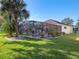 Back yard view of a home with an enclosed pool and manicured lawn at 22204 Caledonia Dr, Leesburg, FL 34748