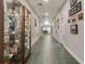 Hallway featuring built-in display cases, art, green tiled floors, and views to other rooms at 22204 Caledonia Dr, Leesburg, FL 34748