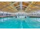 Bright indoor pool area with large windows, high ceilings, and people swimming and enjoying the amenities at 22204 Caledonia Dr, Leesburg, FL 34748