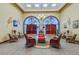 The community lobby features elegant seating, arched doorways, and a chandelier that adds sophistication at 22204 Caledonia Dr, Leesburg, FL 34748