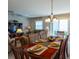 Dining area with a table set for six, adjacent to the living room at 2479 Cedar Key Ln, The Villages, FL 32162