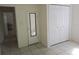 Simple bedroom featuring tiled floors, a mirrored door, and a closet, offering a clean and functional space at 405 N Rhodes St, Mount Dora, FL 32757