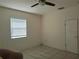 Bright bedroom with neutral walls, tiled flooring, and a ceiling fan at 405 N Rhodes St, Mount Dora, FL 32757