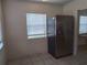 Kitchen showcasing stainless steel refrigerator, tiled floors, and bright windows at 405 N Rhodes St, Mount Dora, FL 32757