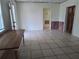 Bright living room with tile floors, a table, and multiple entryways at 405 N Rhodes St, Mount Dora, FL 32757