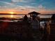 Picturesque sunset view of a charming lake dock with a covered sitting area on the water at 6118 Dora Dr, Mount Dora, FL 32757