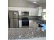 Bright kitchen featuring stainless steel appliances and granite countertops at 928 Nuthatch Ave, The Villages, FL 32163