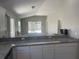 Kitchen with granite countertop peninsula overlooking the living room at 928 Nuthatch Ave, The Villages, FL 32163