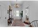 Charming entryway with chandelier, cabinet and patterned rug offering a warm welcome into the home at 1132 Maynard Path, The Villages, FL 32163