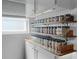 Efficient kitchen storage with jars on shelves, designed to organize and display spices next to a window at 1132 Maynard Path, The Villages, FL 32163