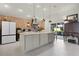 Modern kitchen featuring a large island, brick accent wall, and contemporary lighting at 1132 Maynard Path, The Villages, FL 32163