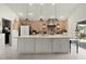 Well-lit kitchen featuring a large island, brick accent wall and modern appliances at 1132 Maynard Path, The Villages, FL 32163