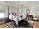 Spacious main bedroom features a four poster bed, decorative rug, and classic furnishings under a decorative ceiling at 1132 Maynard Path, The Villages, FL 32163