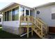 Wooden deck with stairs leading to a sunroom at 227 Pinewood Dr, Eustis, FL 32726