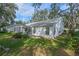 White house exterior with a screened porch and yard at 25813 Glen Eagle Dr, Leesburg, FL 34748