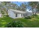 White house exterior with a screened porch and yard at 25813 Glen Eagle Dr, Leesburg, FL 34748