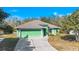 Single-story green house with driveway and canal view at 26701 Bimini Dr, Tavares, FL 32778