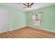 The bedroom has wood flooring, a ceiling fan and a window at 26701 Bimini Dr, Tavares, FL 32778