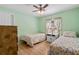 Bedroom with two twin beds, floral bedding, and ceiling fan at 26701 Bimini Dr, Tavares, FL 32778