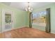 Dining room with light green walls, wood floors, and a sliding glass door to the lanai at 26701 Bimini Dr, Tavares, FL 32778