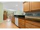 Kitchen with wooden cabinets, granite counters, and view into the dining area at 26701 Bimini Dr, Tavares, FL 32778