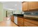 Light-filled kitchen with black countertops, sleek appliances, and light wood cabinetry at 26701 Bimini Dr, Tavares, FL 32778