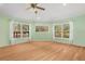 Living room with light green walls, wood floors, and large windows overlooking the water at 26701 Bimini Dr, Tavares, FL 32778