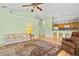 Living room with light green walls, area rug, and ceiling fan at 26701 Bimini Dr, Tavares, FL 32778